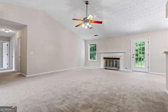 unfurnished living room featuring carpet, vaulted ceiling, ceiling fan, and a healthy amount of sunlight