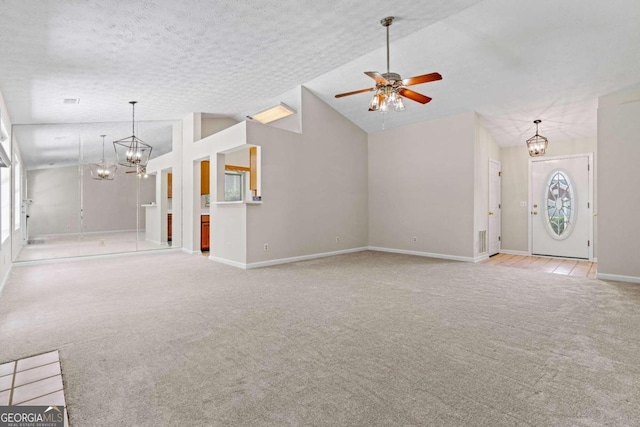 unfurnished living room featuring ceiling fan with notable chandelier, a textured ceiling, light colored carpet, and high vaulted ceiling