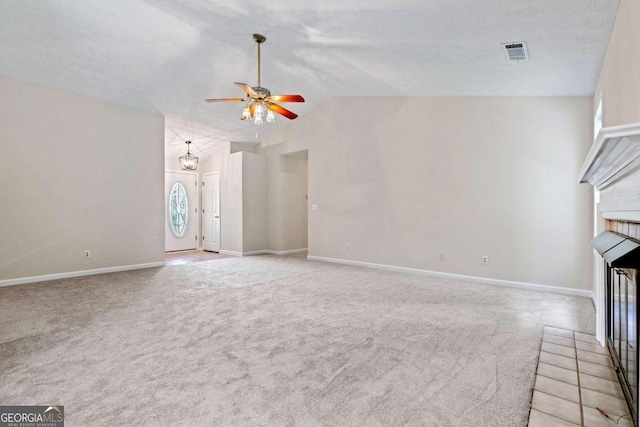 unfurnished living room featuring a textured ceiling, lofted ceiling, ceiling fan, and light colored carpet