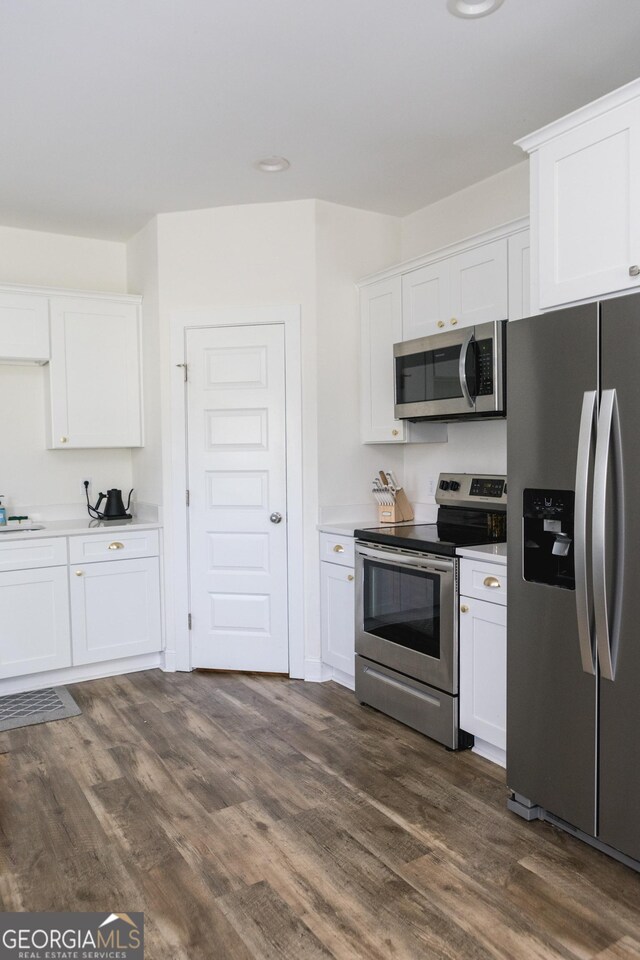 kitchen featuring white cabinets, appliances with stainless steel finishes, and dark hardwood / wood-style floors