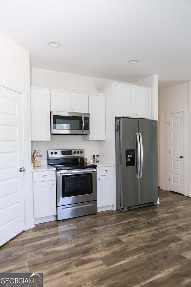 kitchen featuring stainless steel appliances, dark hardwood / wood-style floors, and white cabinets