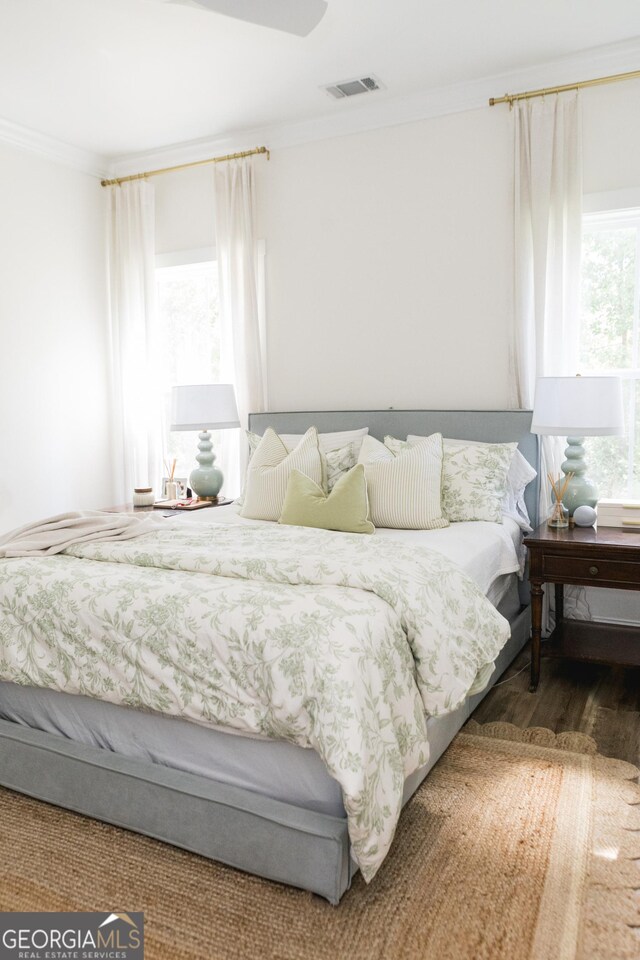 bedroom with wood-type flooring and ornamental molding