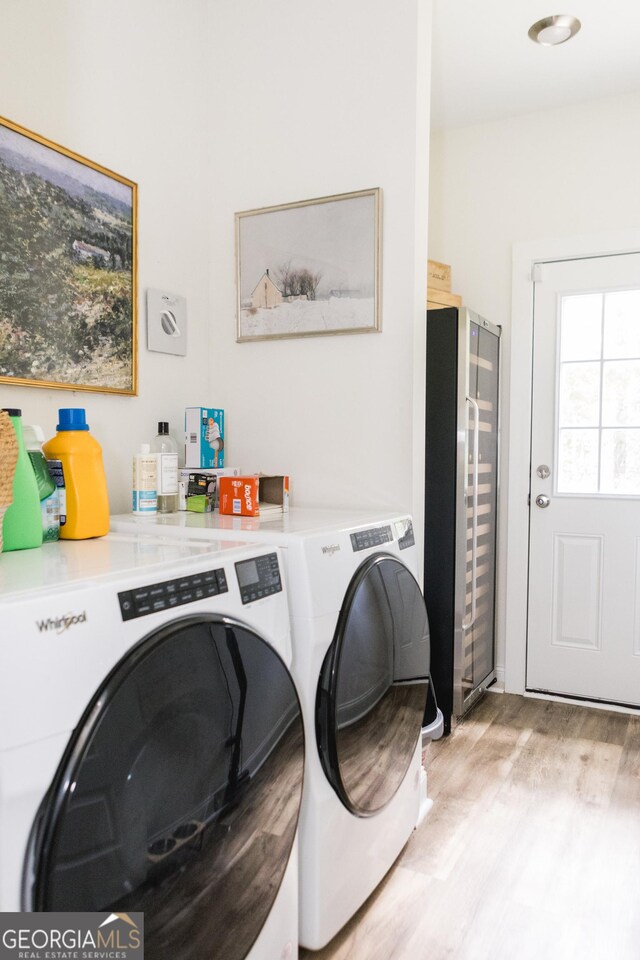 clothes washing area featuring light wood-type flooring and independent washer and dryer