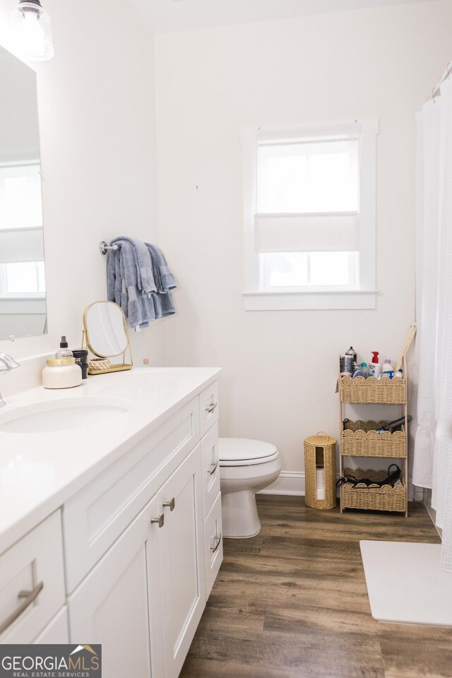 bathroom featuring toilet, vanity, and hardwood / wood-style flooring