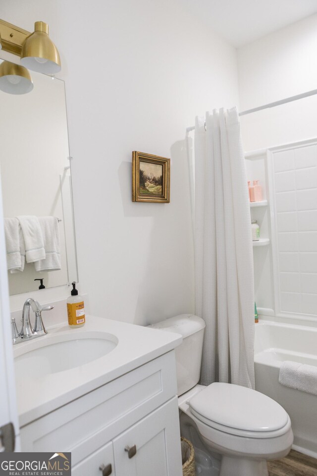 full bathroom featuring wood-type flooring, vanity, toilet, and shower / bath combo with shower curtain