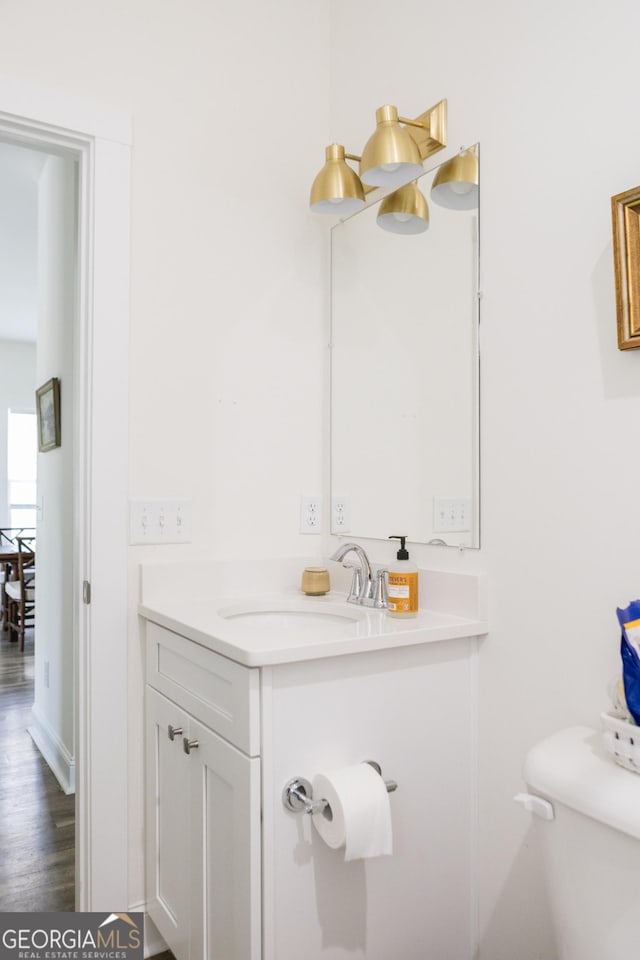 bathroom with vanity, toilet, and wood-type flooring