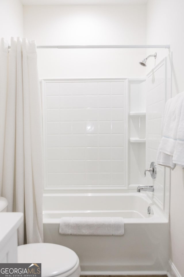 bathroom featuring shower / bathtub combination with curtain and toilet