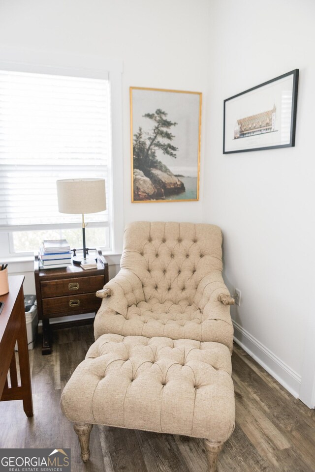 sitting room with plenty of natural light and dark wood-type flooring