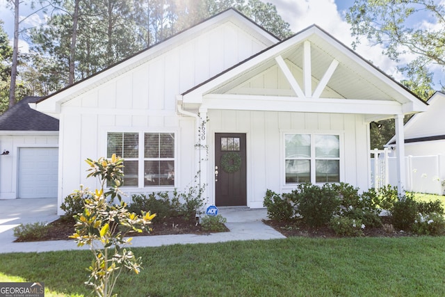 view of front of home featuring a porch, a garage, and a front yard