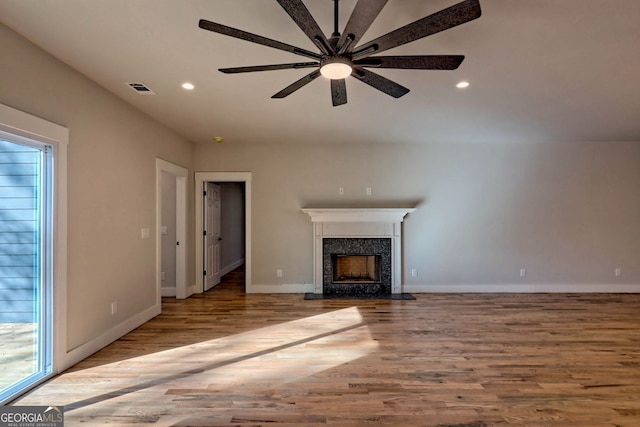 unfurnished living room with light wood-type flooring and ceiling fan