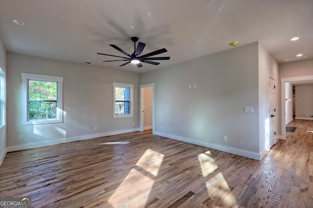 empty room with ceiling fan and light hardwood / wood-style floors