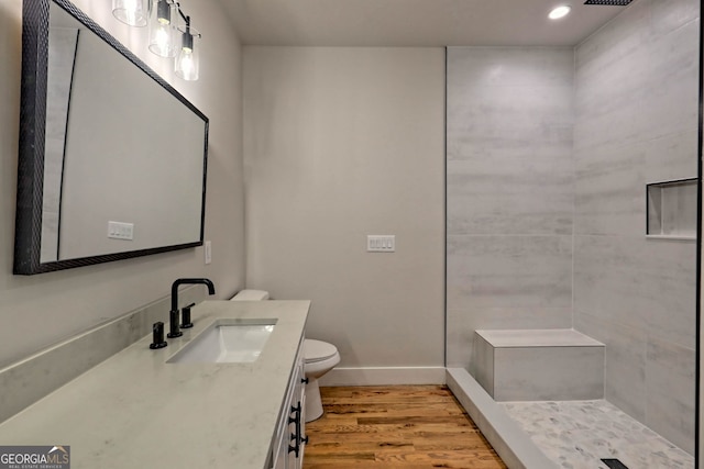 bathroom with toilet, vanity, wood-type flooring, and walk in shower