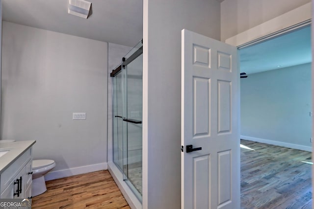 bathroom featuring vanity, hardwood / wood-style flooring, toilet, and an enclosed shower