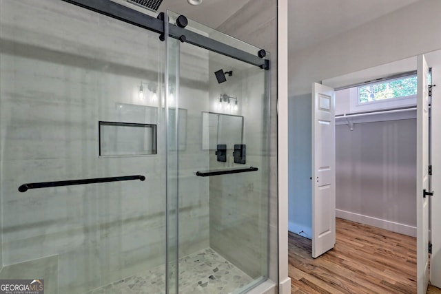 bathroom with an enclosed shower and hardwood / wood-style flooring