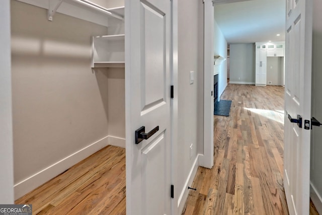 hallway with light hardwood / wood-style floors