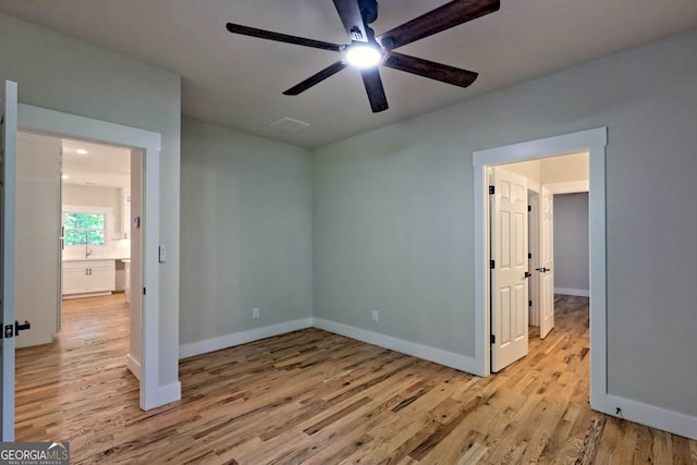 unfurnished bedroom with ceiling fan and light wood-type flooring