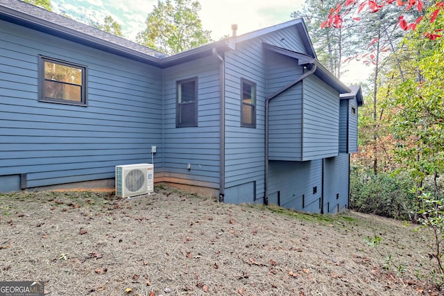 view of side of home with ac unit