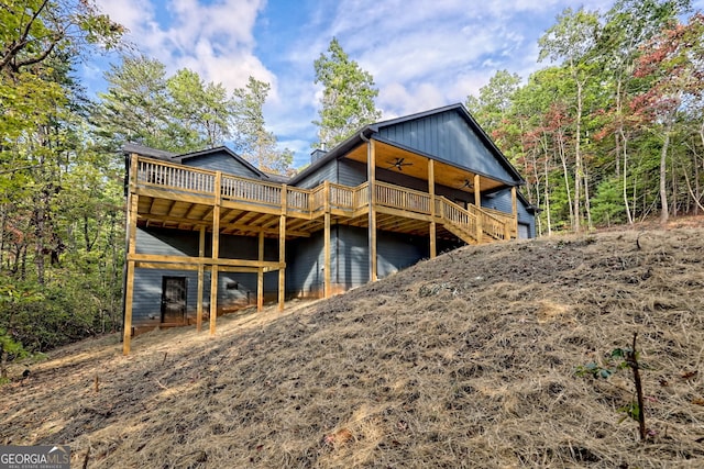 back of house featuring ceiling fan and a wooden deck