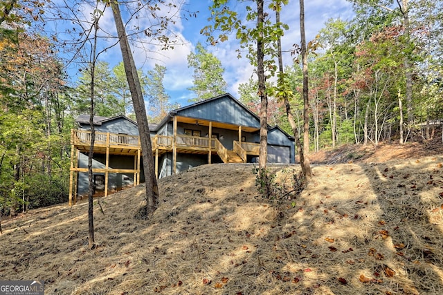 rear view of house with an outbuilding, a deck, and a garage