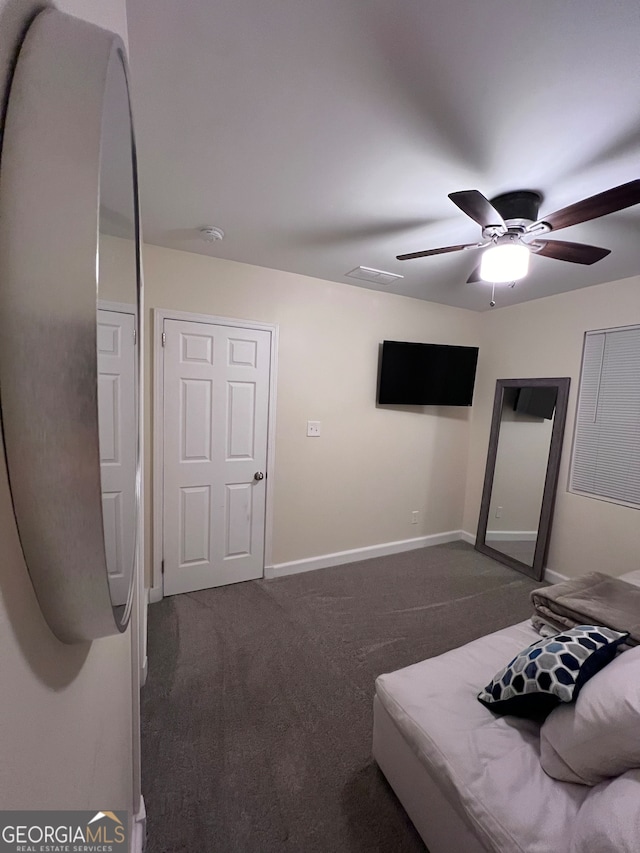 unfurnished bedroom with ceiling fan and dark colored carpet