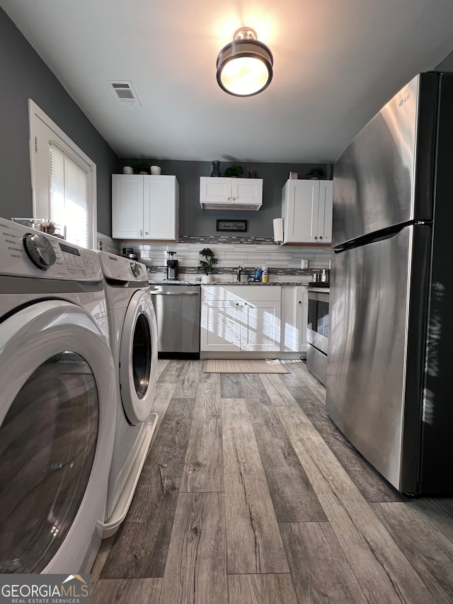 washroom featuring hardwood / wood-style flooring and separate washer and dryer