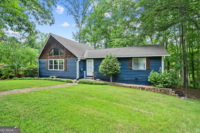 view of front of home with a front yard and roof with shingles