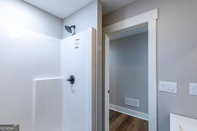 bathroom with walk in shower and hardwood / wood-style floors