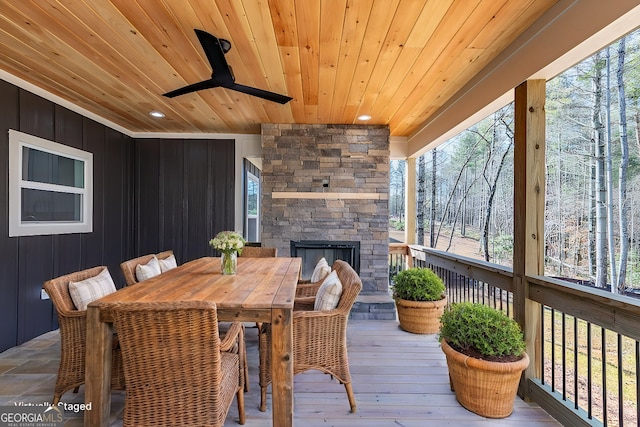 wooden deck featuring ceiling fan and an outdoor stone fireplace