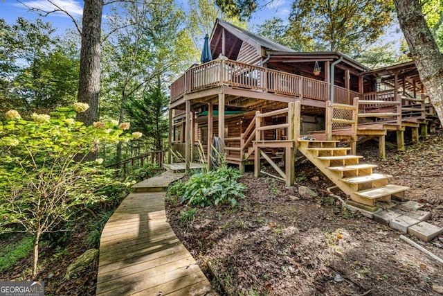 rear view of house featuring a wooden deck