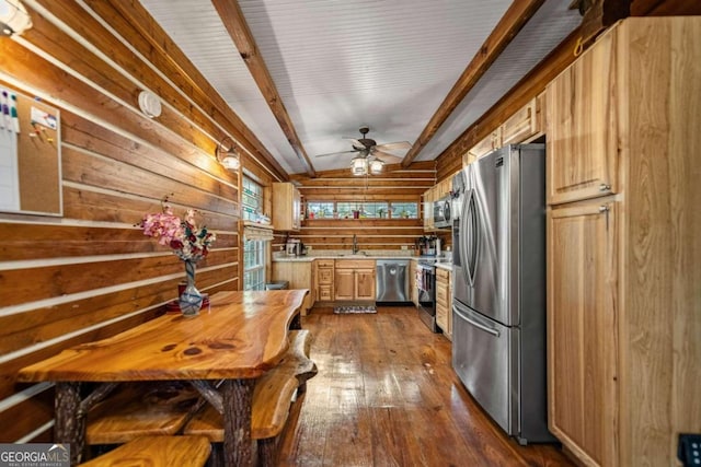 kitchen featuring appliances with stainless steel finishes, light brown cabinetry, ceiling fan, wooden walls, and dark hardwood / wood-style floors