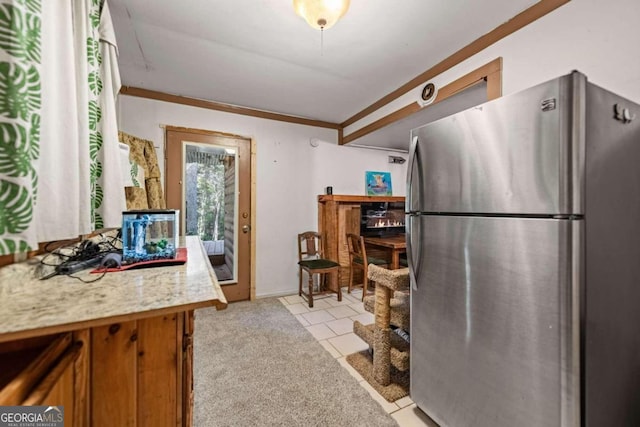 kitchen featuring light carpet, stainless steel fridge, and crown molding