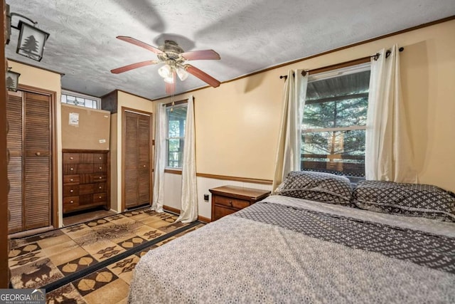 bedroom featuring ceiling fan, light tile patterned floors, and a textured ceiling