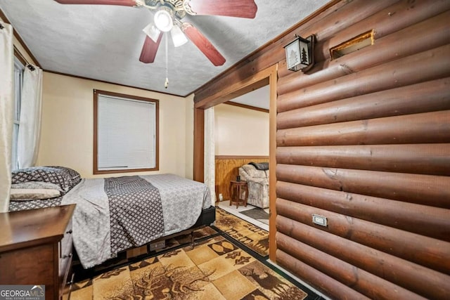 bedroom with ceiling fan, a textured ceiling, and log walls