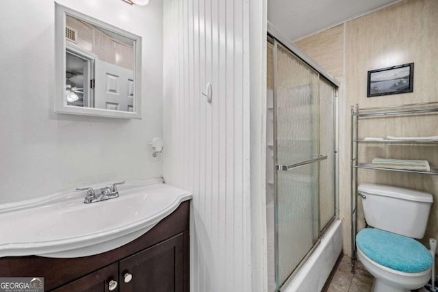 full bathroom featuring enclosed tub / shower combo, vanity, tile patterned flooring, and toilet