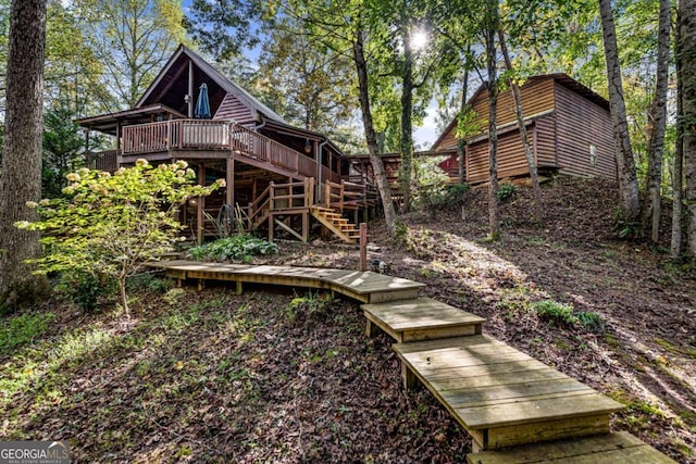 rear view of house featuring a wooden deck