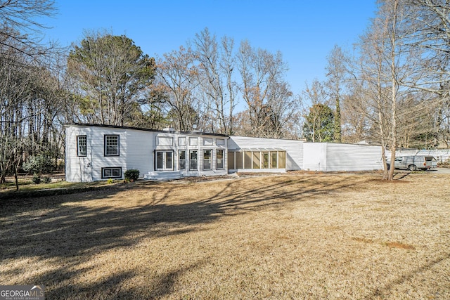 rear view of property featuring a yard