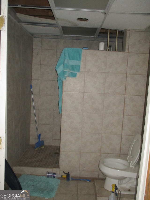 bathroom featuring tile patterned flooring, walk in shower, and toilet