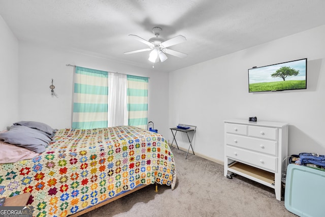 bedroom featuring a textured ceiling, ceiling fan, and light colored carpet