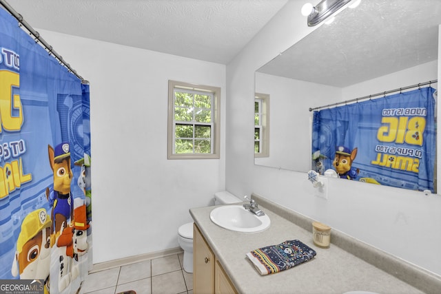 bathroom with curtained shower, vanity, a textured ceiling, toilet, and tile patterned floors