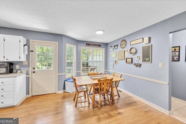 dining room with a textured ceiling and light hardwood / wood-style floors