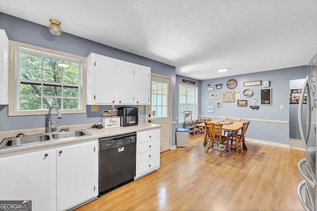 kitchen featuring a healthy amount of sunlight, light hardwood / wood-style floors, dishwasher, and sink