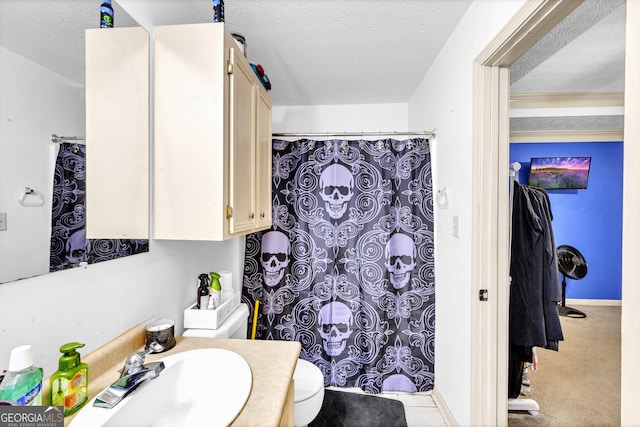 bathroom featuring vanity, a textured ceiling, and toilet