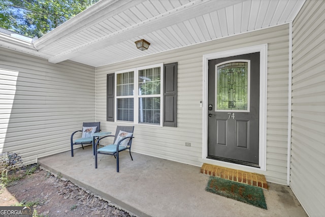 view of exterior entry featuring covered porch