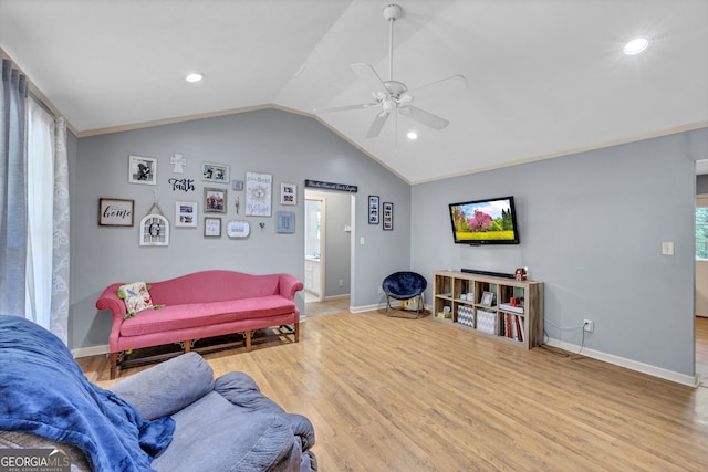 living room with ceiling fan, lofted ceiling, and light hardwood / wood-style floors