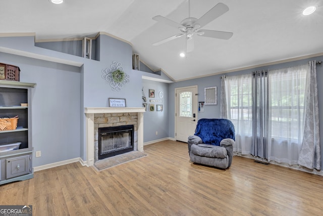 living room with lofted ceiling, light hardwood / wood-style floors, a fireplace, and ceiling fan