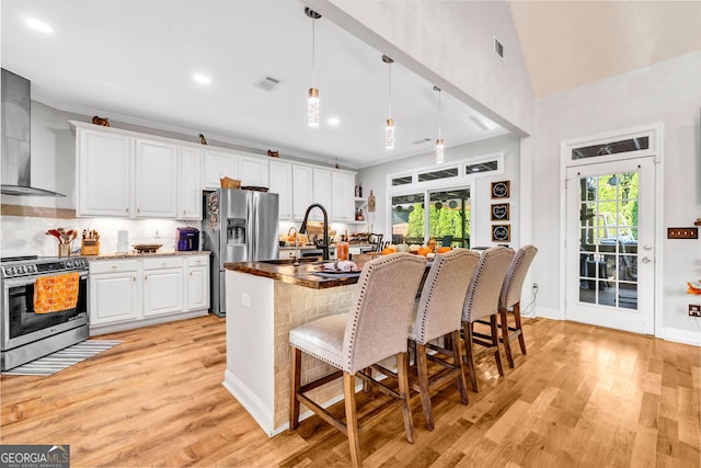 kitchen featuring stainless steel appliances, a healthy amount of sunlight, decorative light fixtures, and white cabinetry