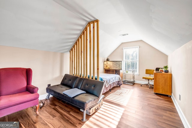 bedroom with vaulted ceiling and wood-type flooring