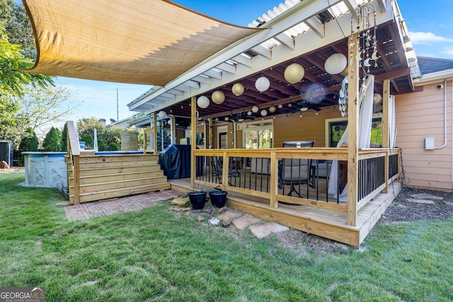 rear view of house with a lawn, a wooden deck, and ceiling fan