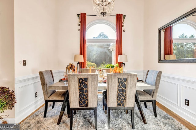 dining space featuring hardwood / wood-style floors and an inviting chandelier