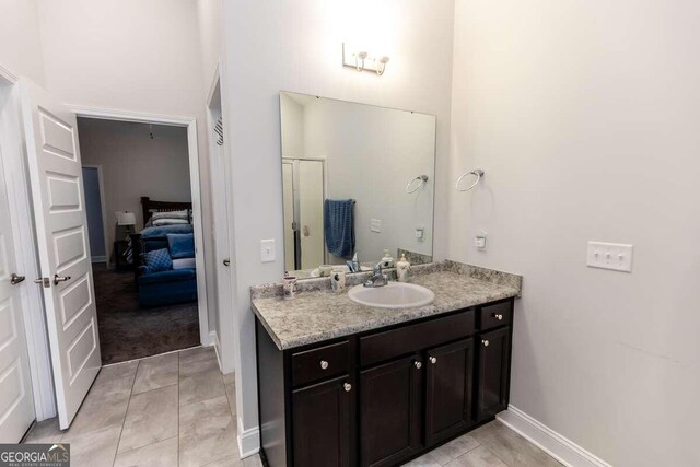 bathroom featuring walk in shower, vanity, and tile patterned floors